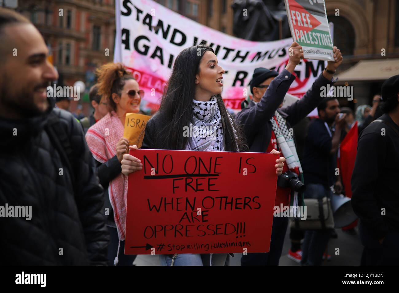 Members of Palestine Action Group Sydney hold placards during a rally