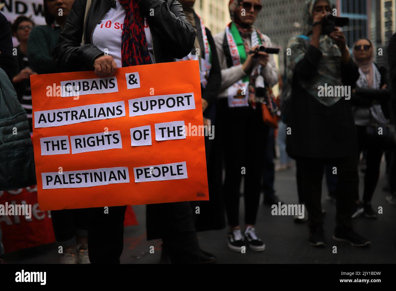 Members of Palestine Action Group Sydney hold placards during a rally