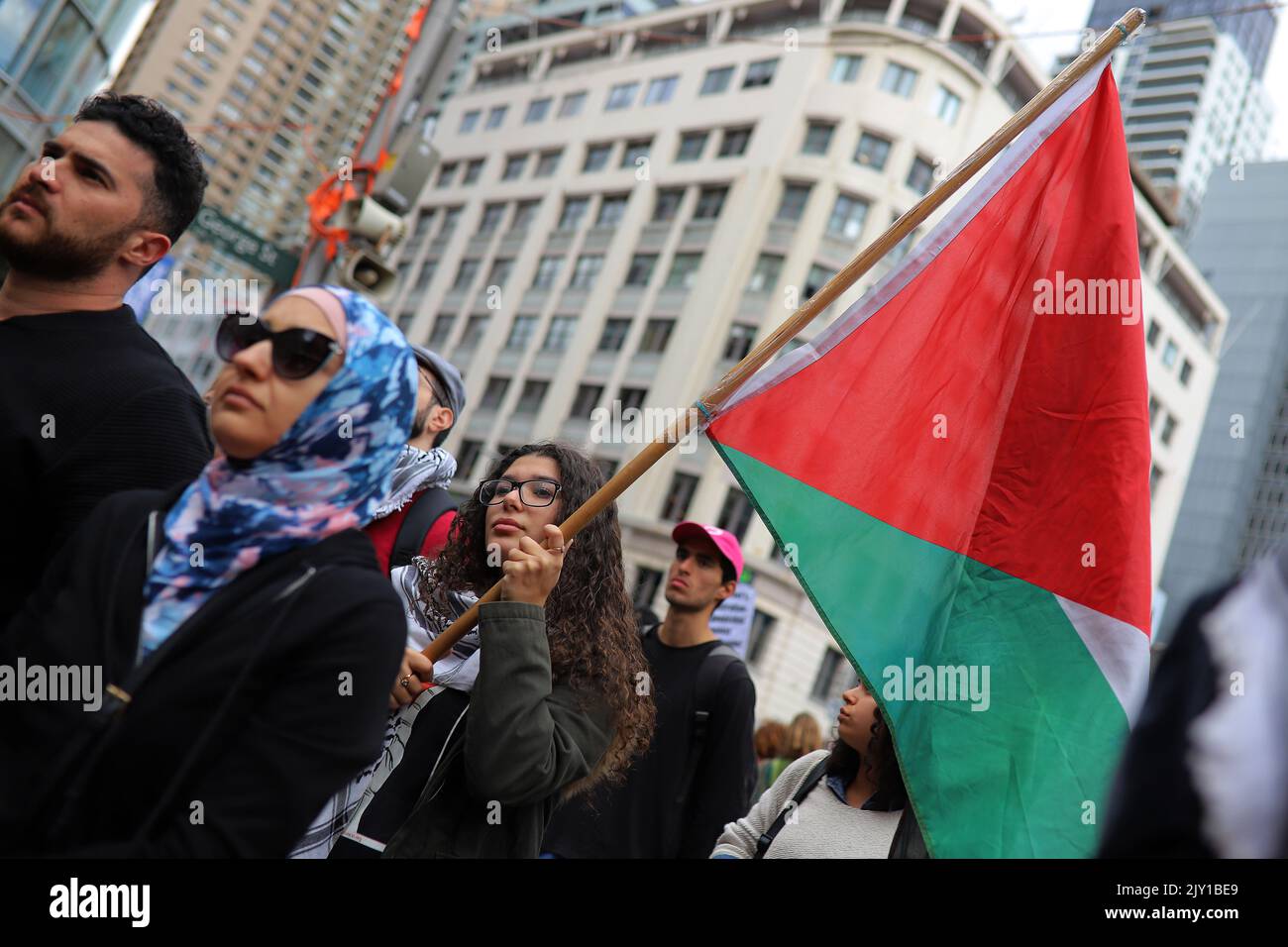 A member of Palestine Action Group Sydney holds a Palestinian flag