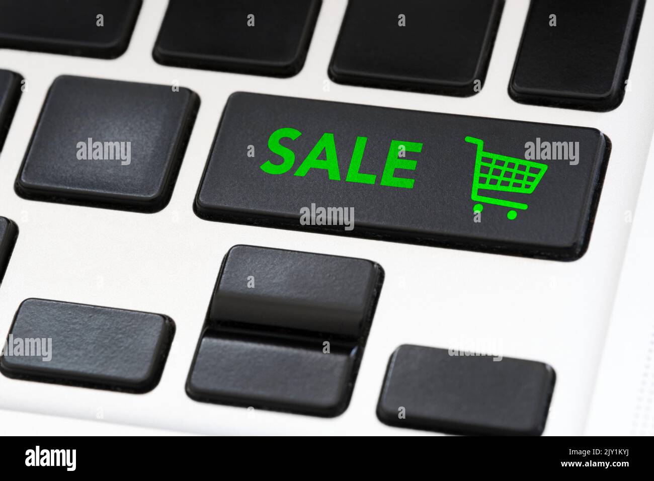 Laptop keypad button with the word Sale and a shopping cart icon. Concepts: online sales, black friday, internet discounts, seasonal rebates. Stock Photo