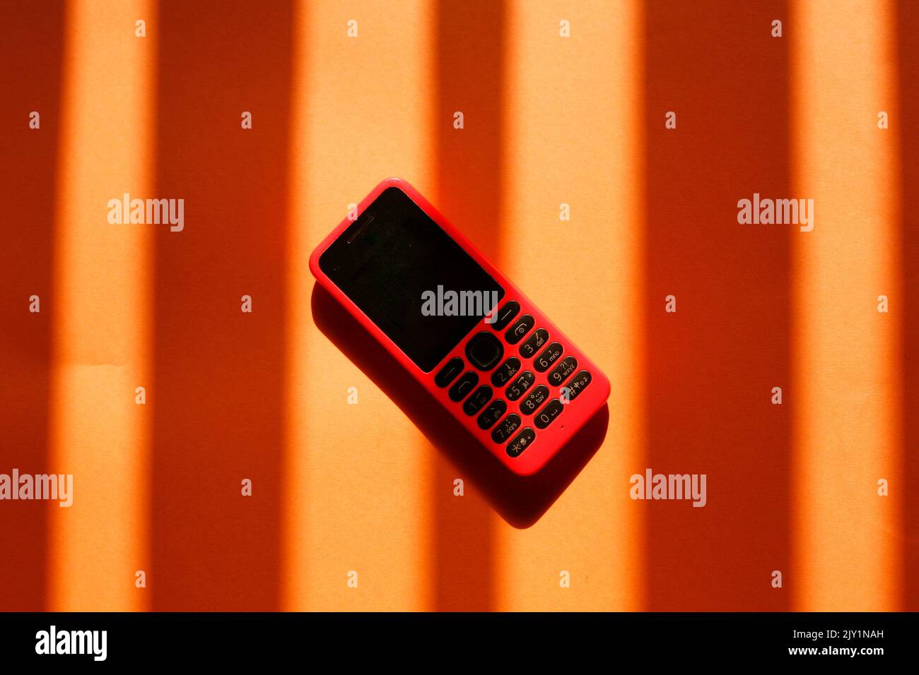 orange cellphone isolated on orange background with shadow Stock Photo
