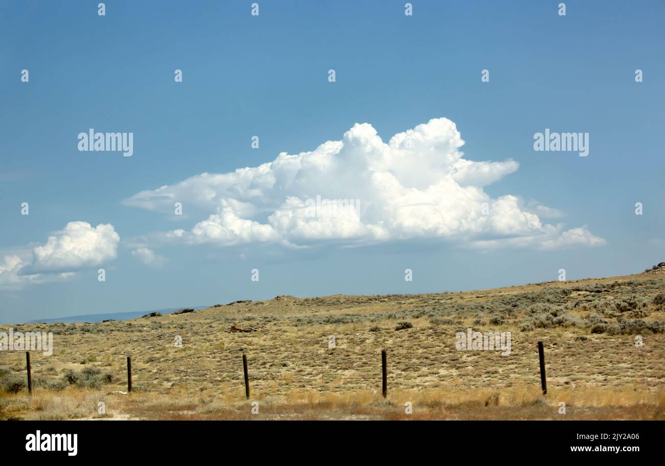 Rural landscape with a fence on the sagebrush steppe rangelands of the Rocky Mountains north of Cody, Wyoming Stock Photo
