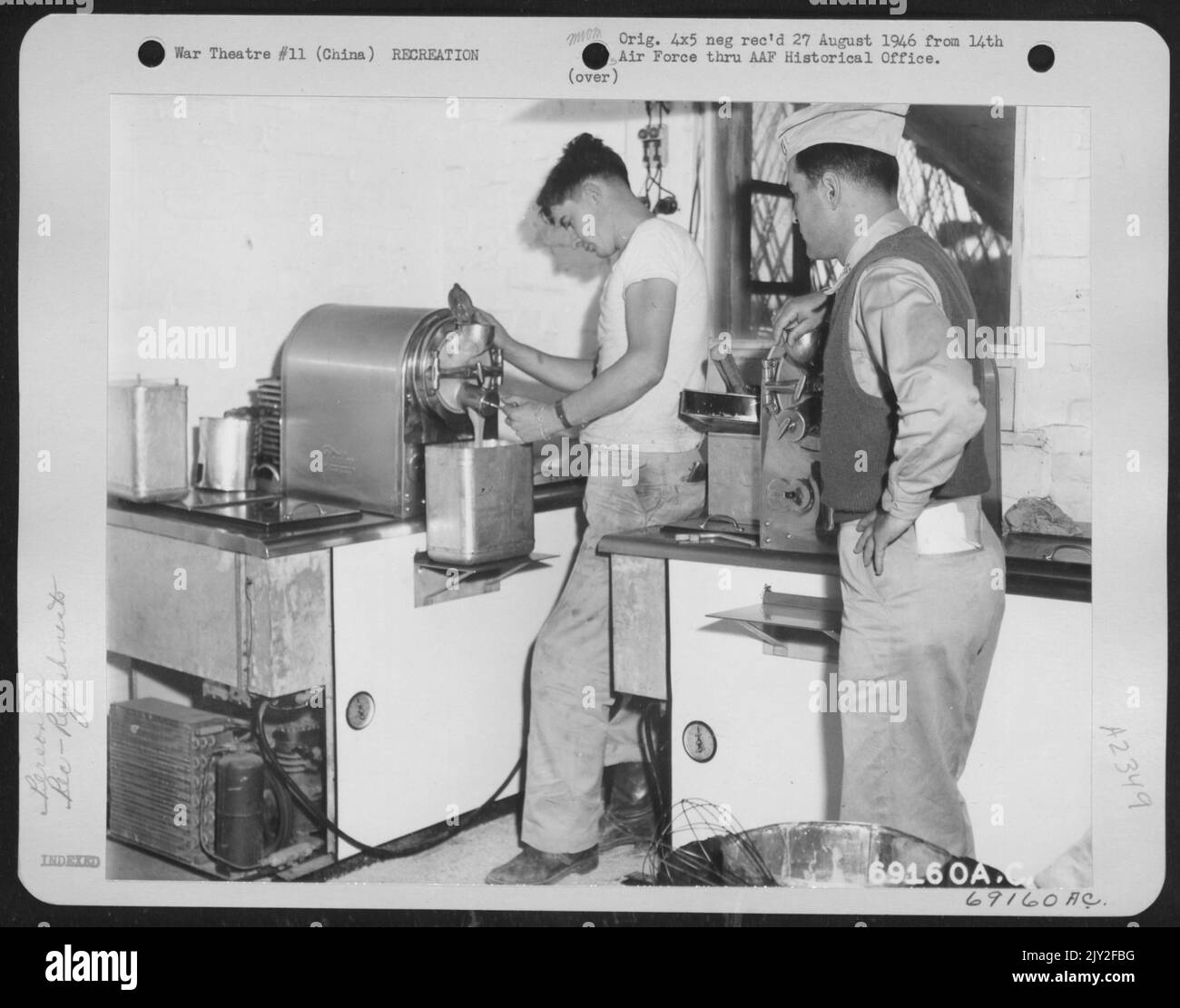 Cpl. James Pringle Of Otis Orchards, Washington, Pours Ice-Cream Into A Container, While Captain Frank Smolkin Of Brooklyn, New York, Looks On. This Modern Ice-Cream Freezer Is The Only One Of Its Kind In China. It Provides Each Man With Ice-Cream Once Stock Photo