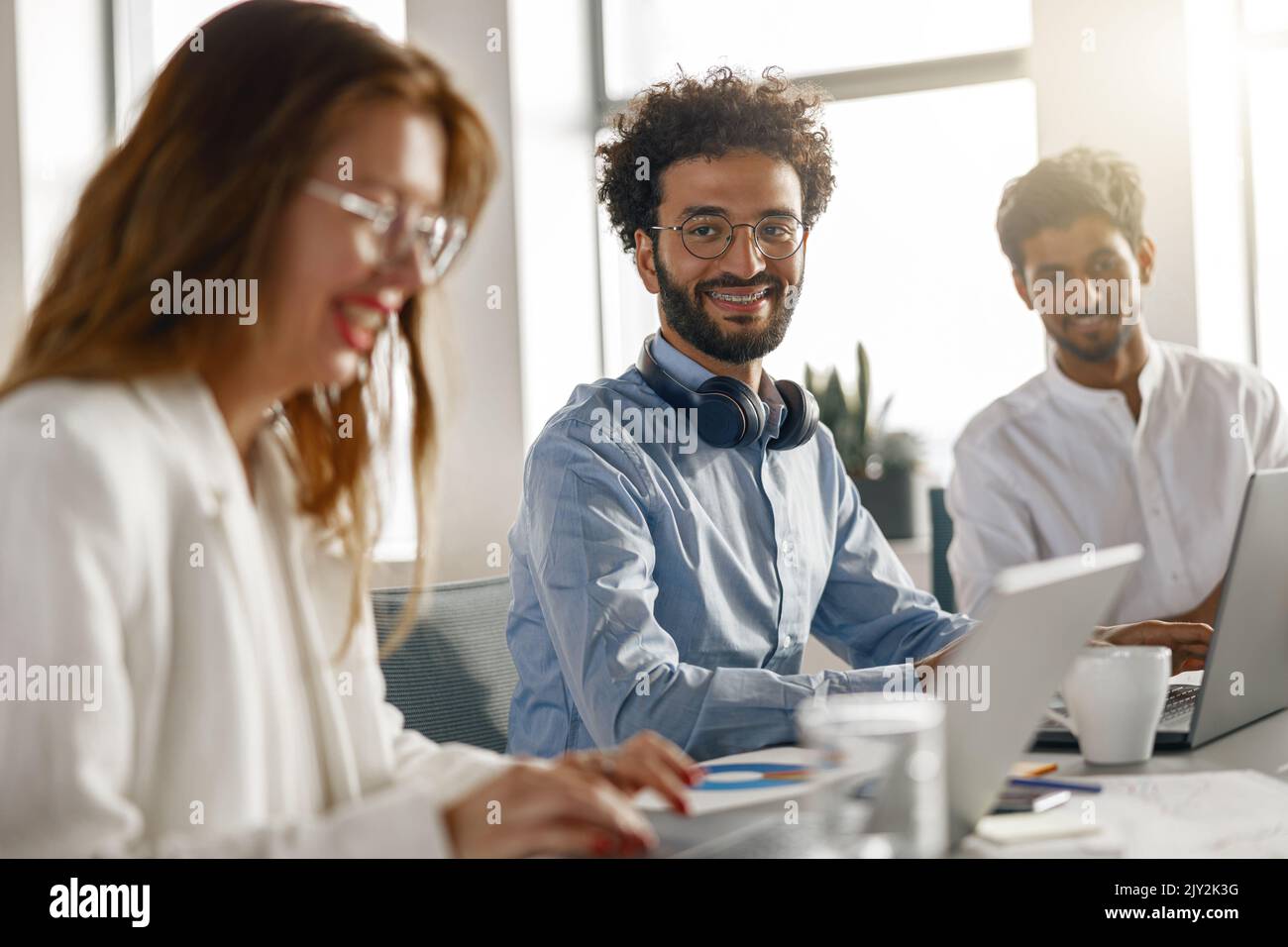 Group of happy coworkers working together analyzing the charts in modern office Stock Photo