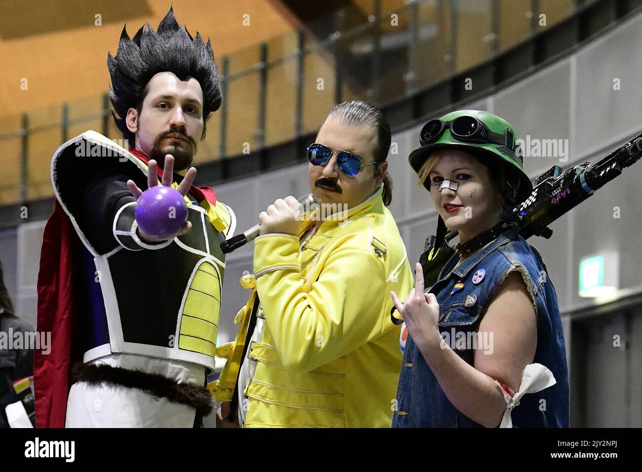 Nathan Raunjak (left) dressed in cosplay as King Vegeta from Dragon Ballz  Super, Joshua Edwards (centre) dressed as Freddie Mercury, and Shannon  Oxley (right) dressed as Tank Girl, pose for a photograph