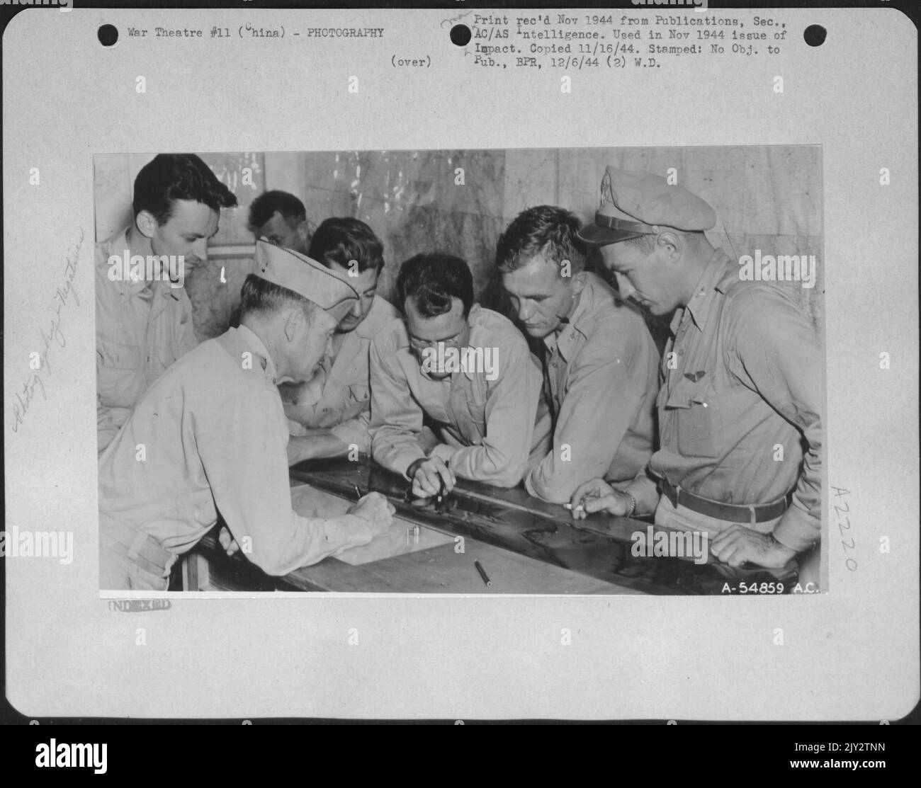 China-Pilot and S-2 Officer watch as photo-interpreters pick negatives ...