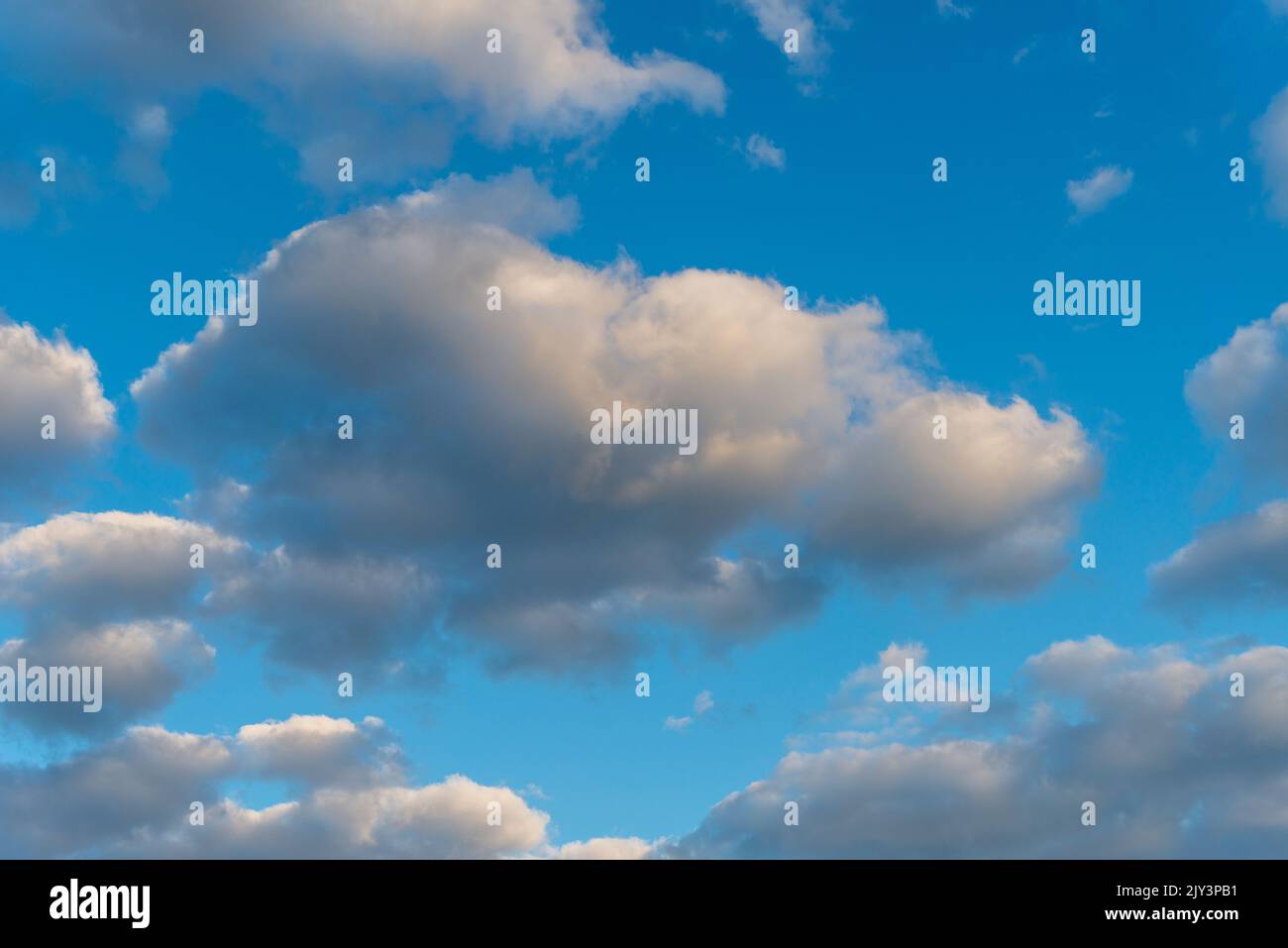 White and dark, fluffy clouds in blue sky. Background from clouds. Stock Photo