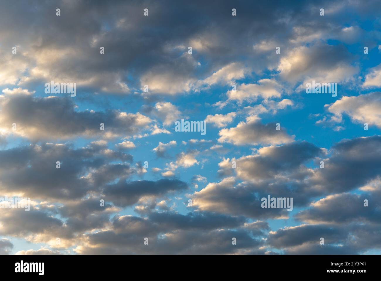 White and dark, fluffy clouds in blue sky. Background from clouds. Stock Photo