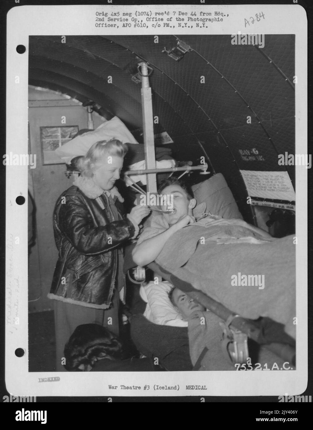 An Air Force Nurse Feed A Patient Aboard A Transport Plane At An Air Base Somewhere In Iceland. 2Nd Service Group, 4 October, 1944. Stock Photo