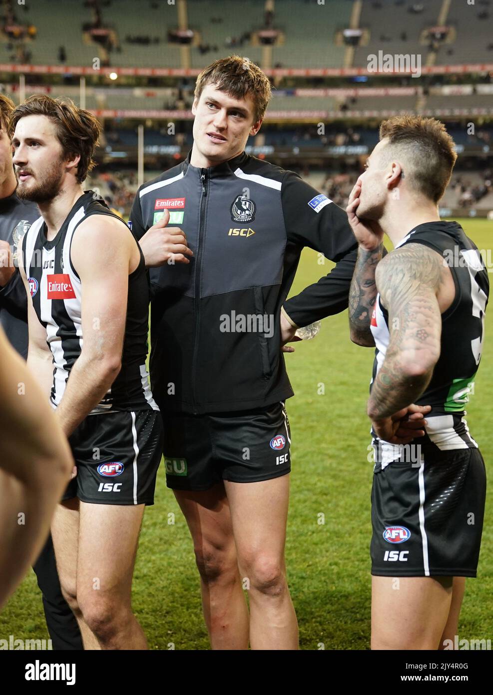 Darcy Moore of the Magpies and his teammates leave the field after