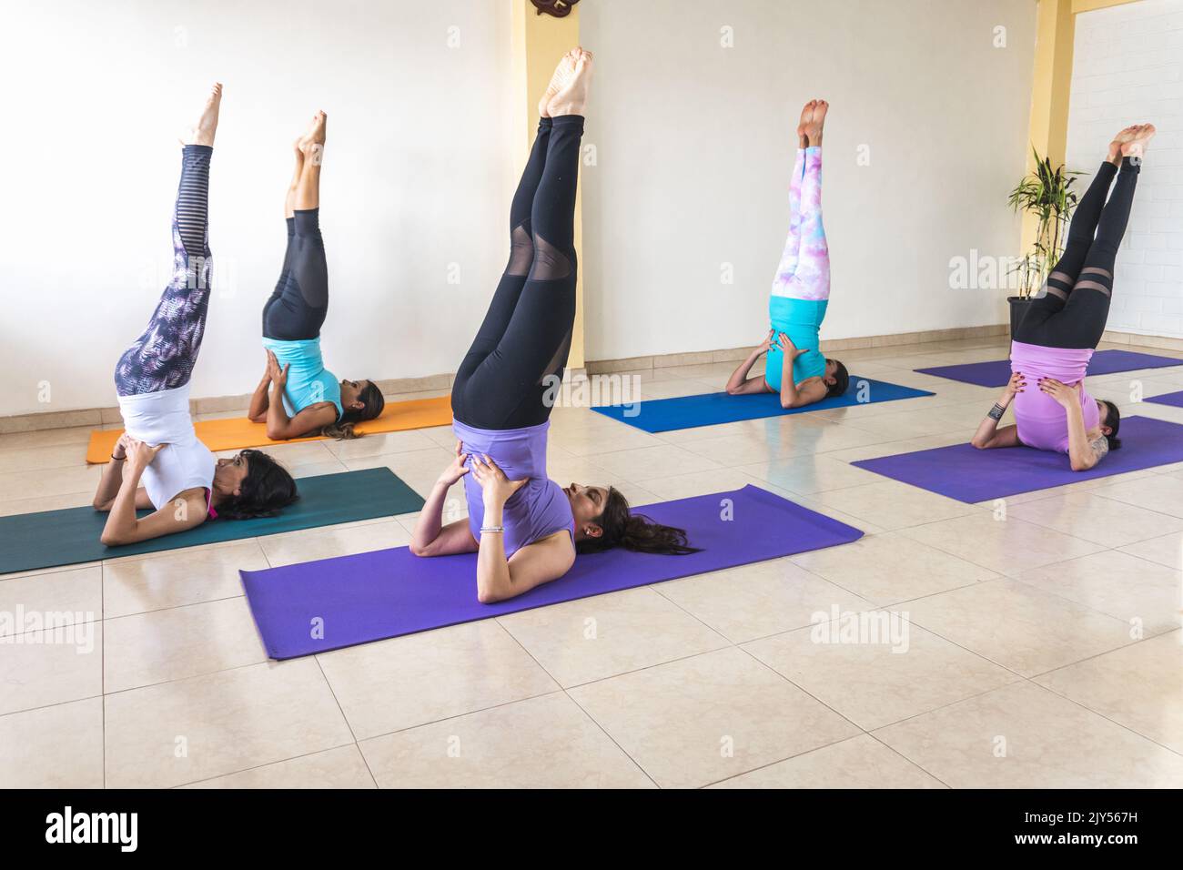 Latina women in candlestick yoga pose during a class Stock Photo