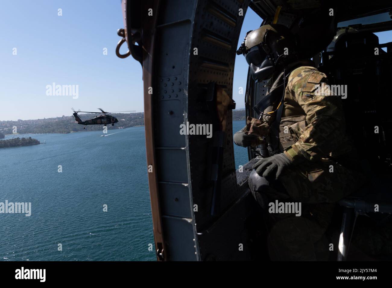 An Australian Army loadmaster looks out from an Army Black Hawk ...