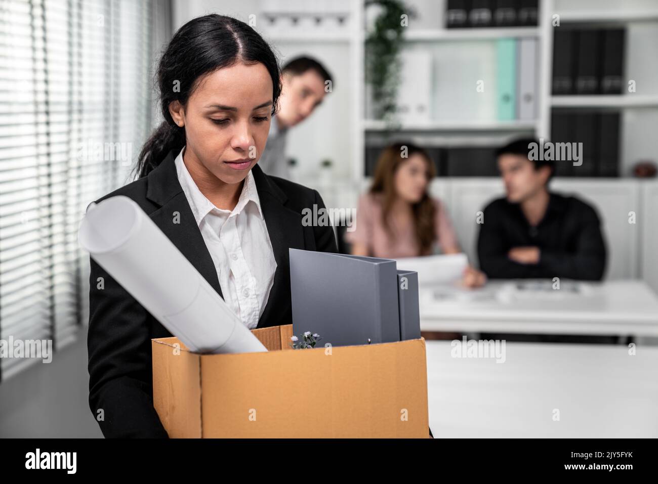 Depressed and disappointed employee packing her belongings after being fired for not being