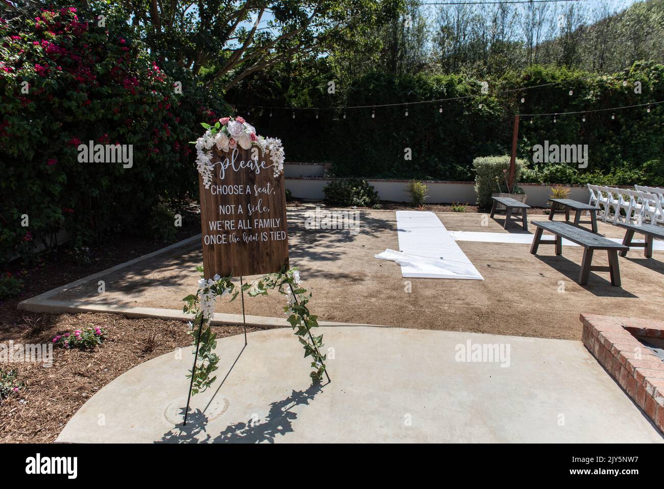 Wedding ceremony sign shows all inclusive seating assignment with freedom to sit on either side of the isle. Stock Photo