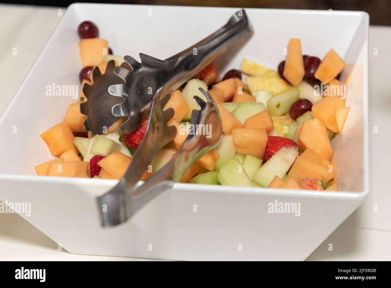 Freshy chopped produce makes a refreshing fruit salad for the guests to serve themselves food to eat. Stock Photo
