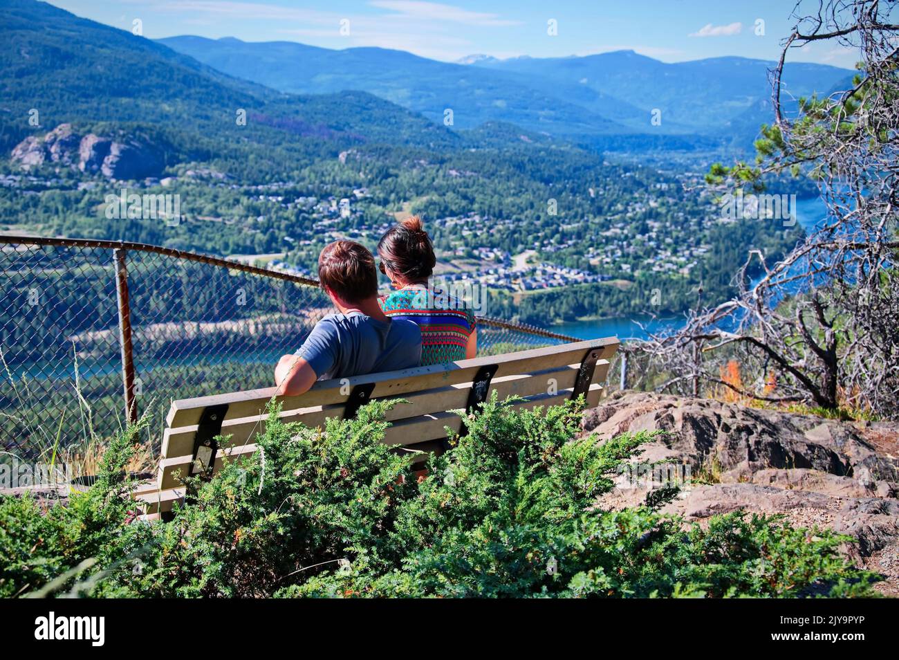 Mature couple sitting on a bench with beautiful view Stock Photo