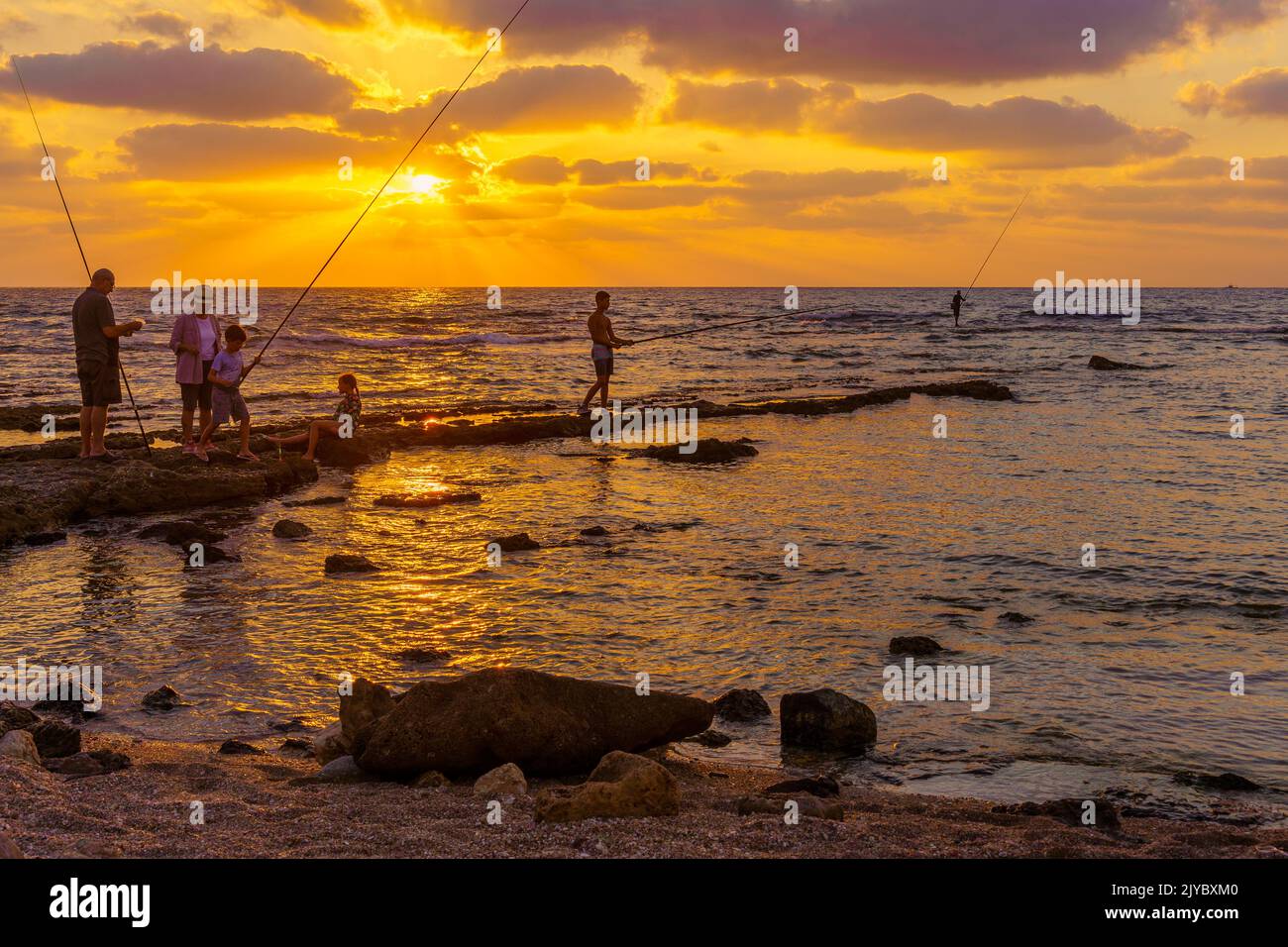Haifa, Israel - September 05, 2022: Sunset scene on the Mediterranean Sea coast, with fishermen. Haifa, Northern Israel Stock Photo