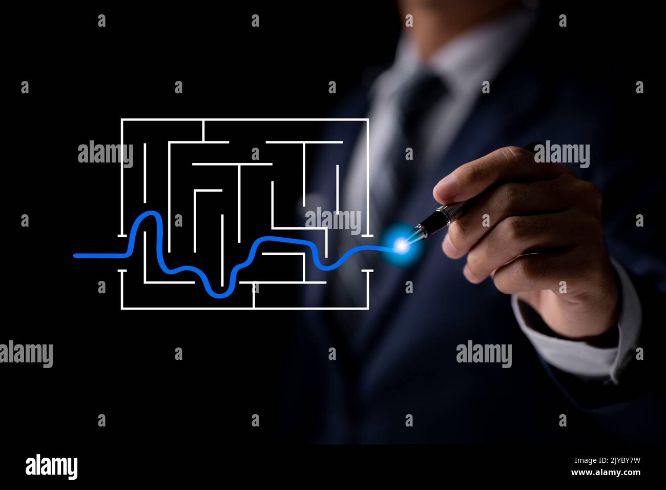 A businessman navigating a maze in a business solution concept. This symbol stands for genius, intelligence, opportunity, challenge, planning, and str Stock Photo