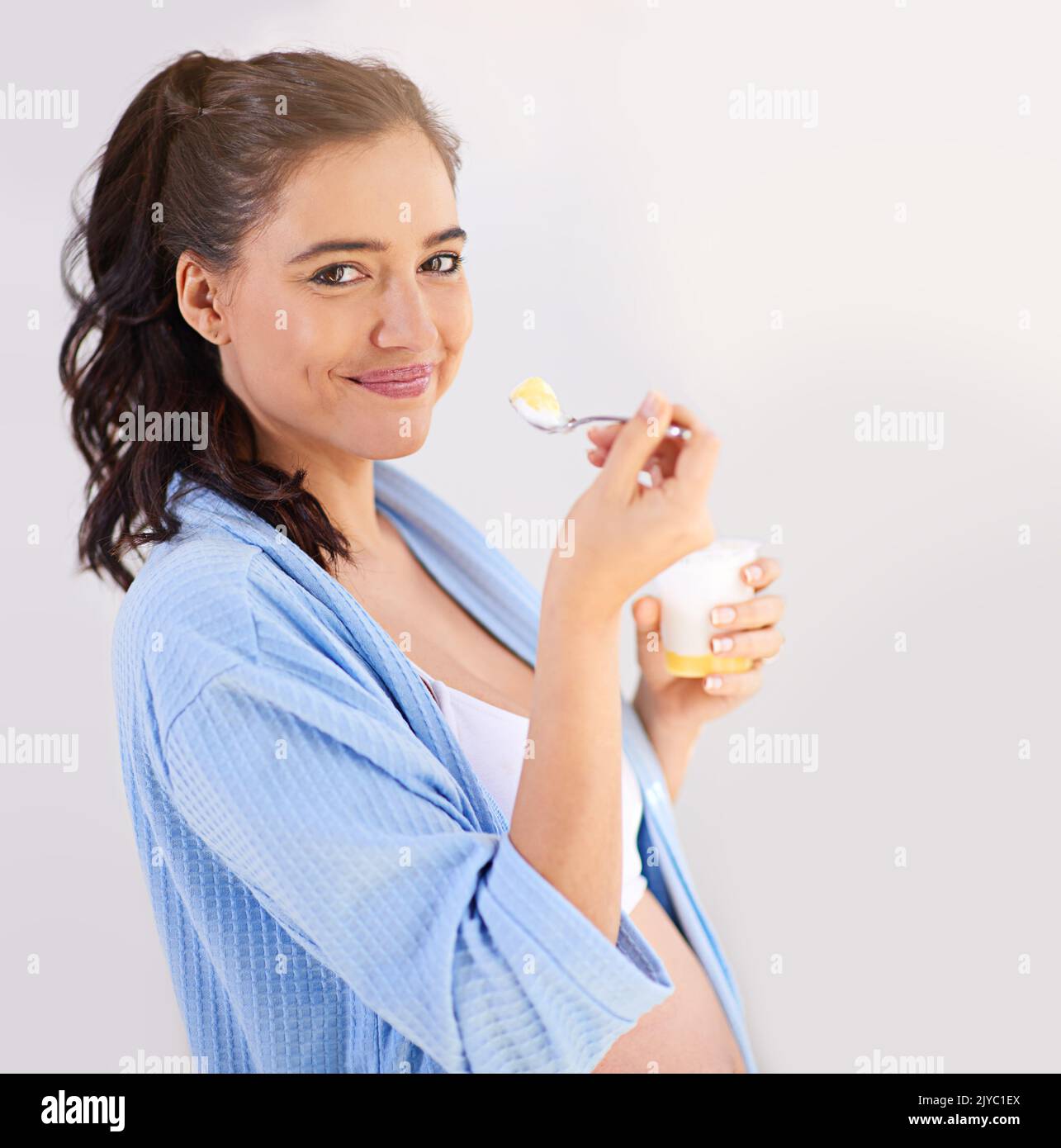 My baby loves yoghurt and so do I. a pregnant woman enjoying a snack at