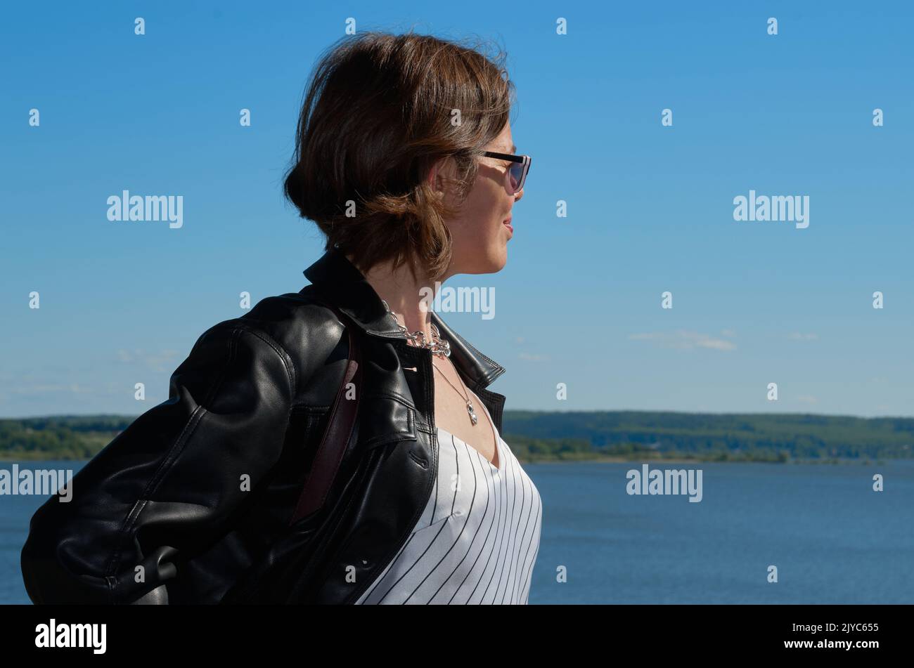 Portrait of woman in leather clothes on summer riverbank Stock Photo ...