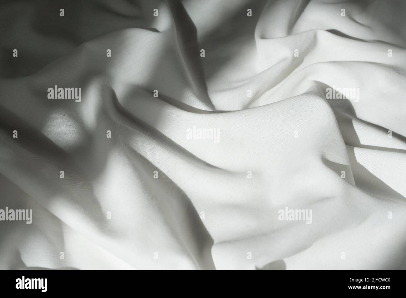 White drapery linen fabric background. Texture of the light surface of