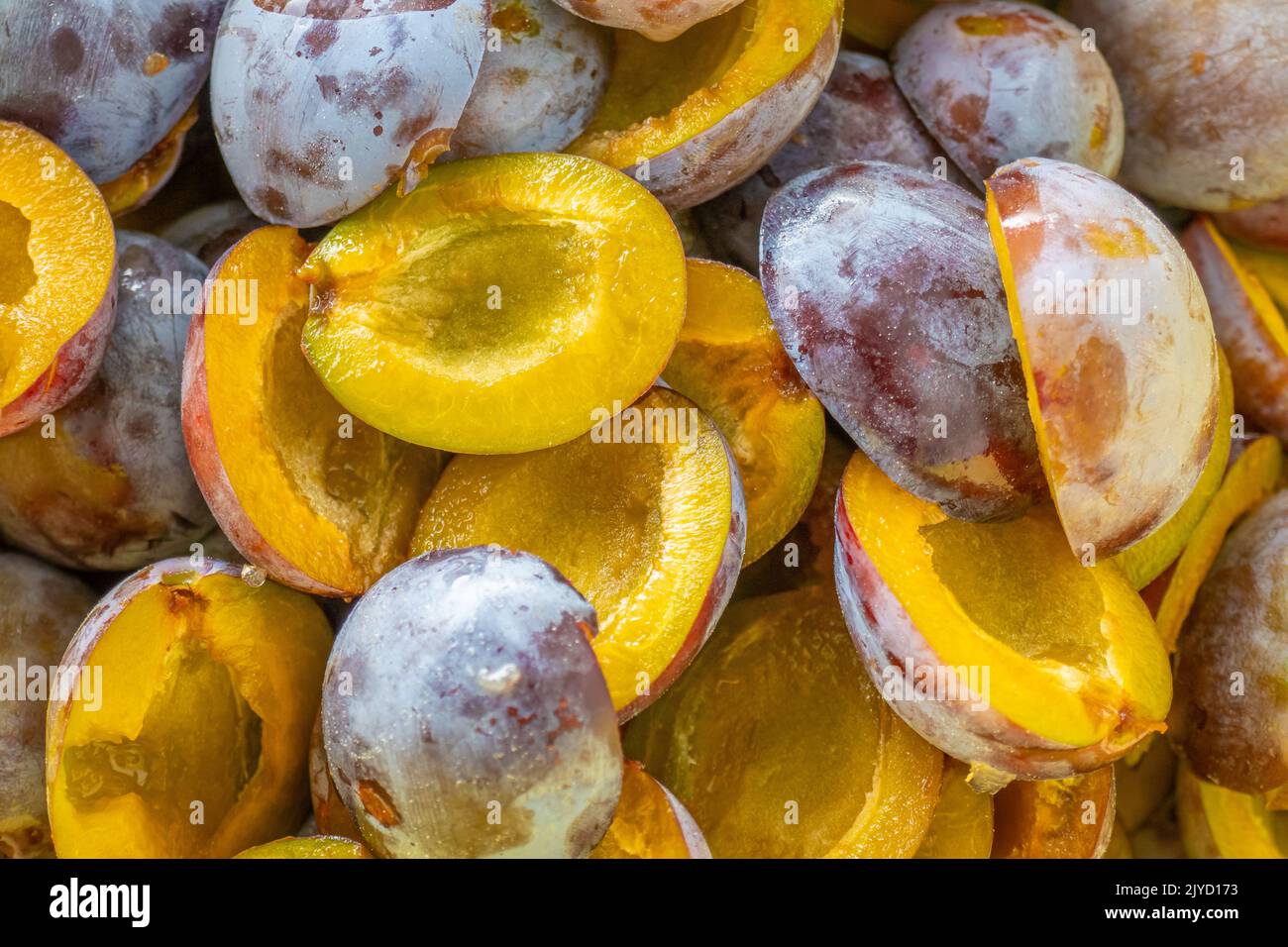 Plums harvest.Plum halves background.Yellow pulp of fruits. Juicy pulp texture.Farm organic
