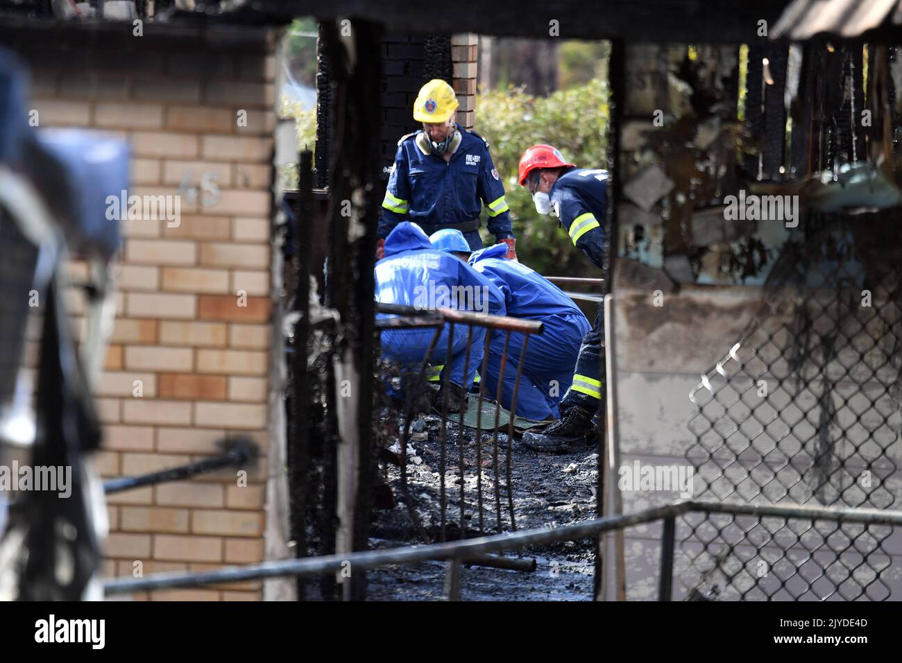 Fire investigators and forensic services at the scene of a house fire