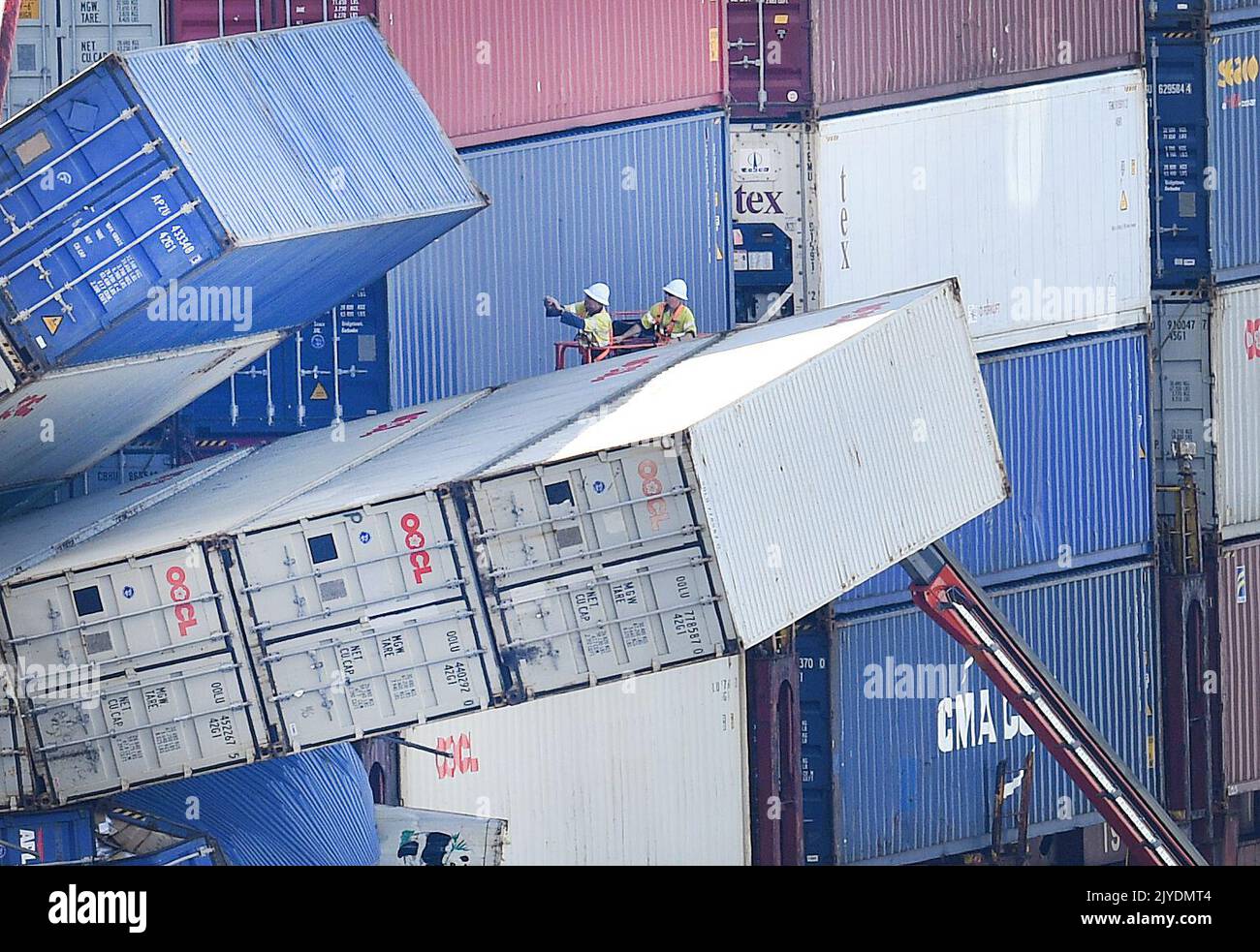 Workers from logistics company QUBE inspect toppled containers on board ...