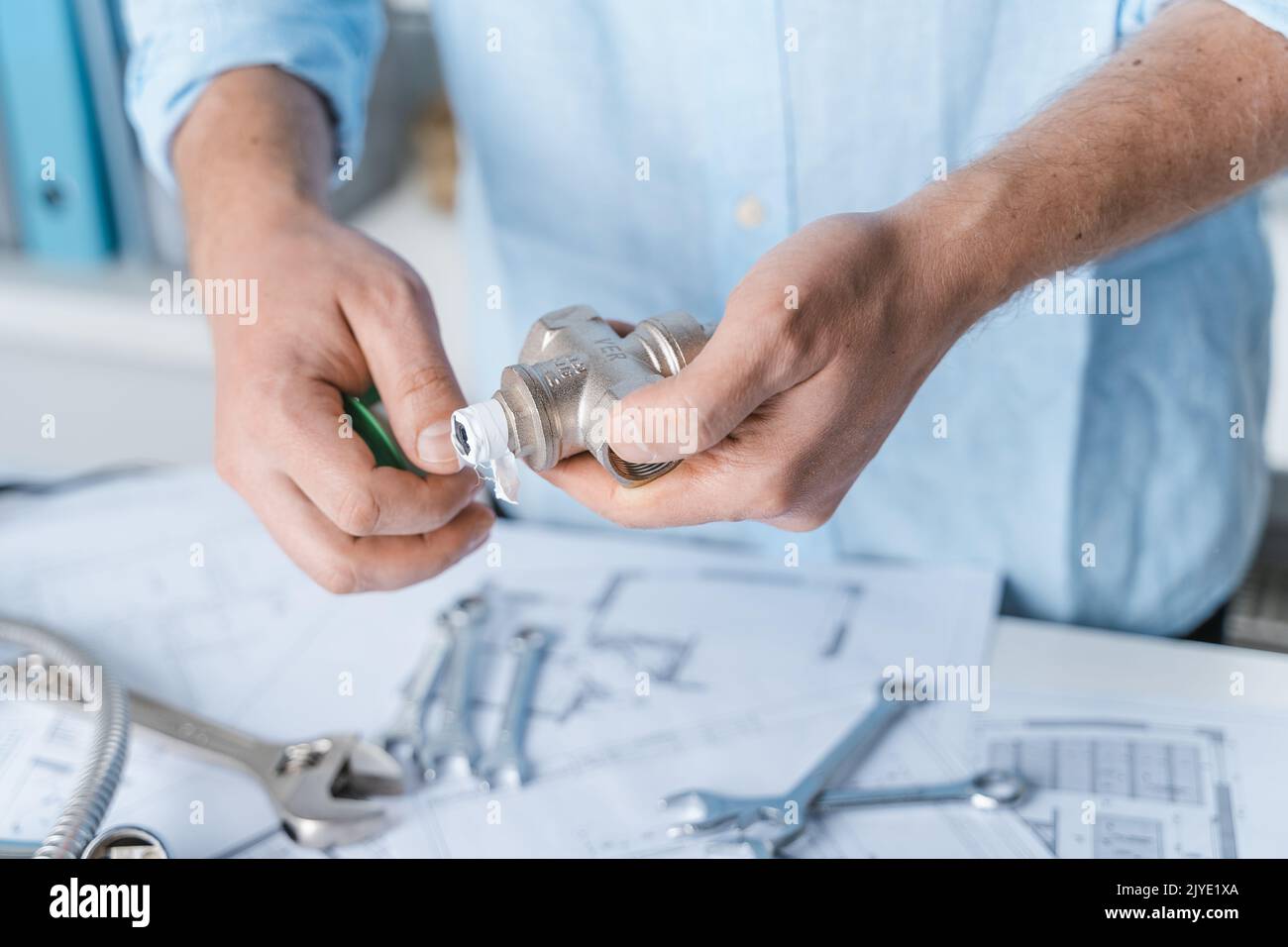 Man repairer,plumber using thread seal tape for reducer sealing