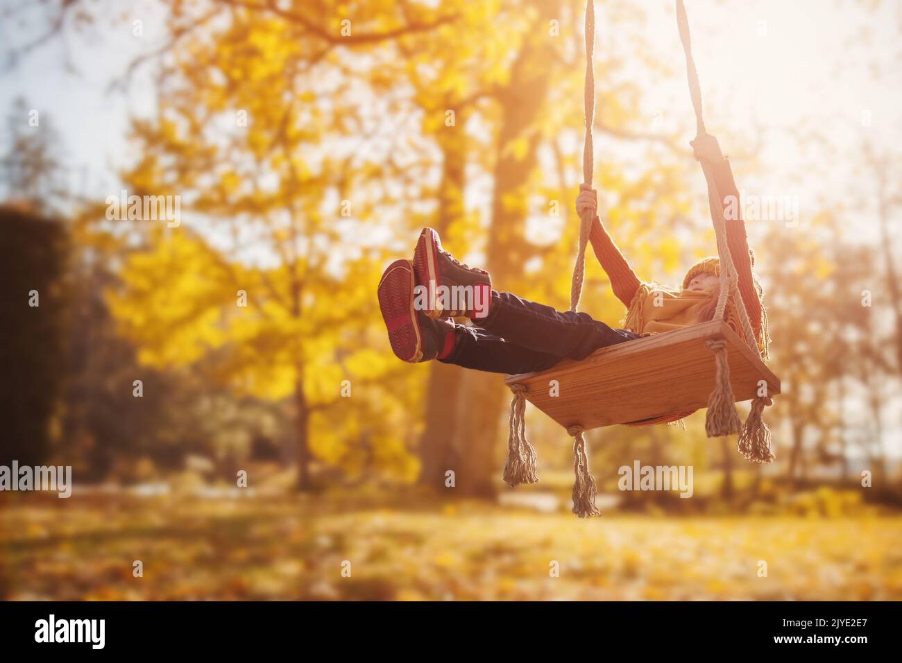 Cute girl swinging on the swing n the sunny park Stock Photo