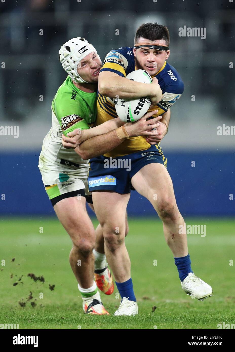 Reed Mahoney of the Eels is tackled by Jarrod Croker of the Raiders ...