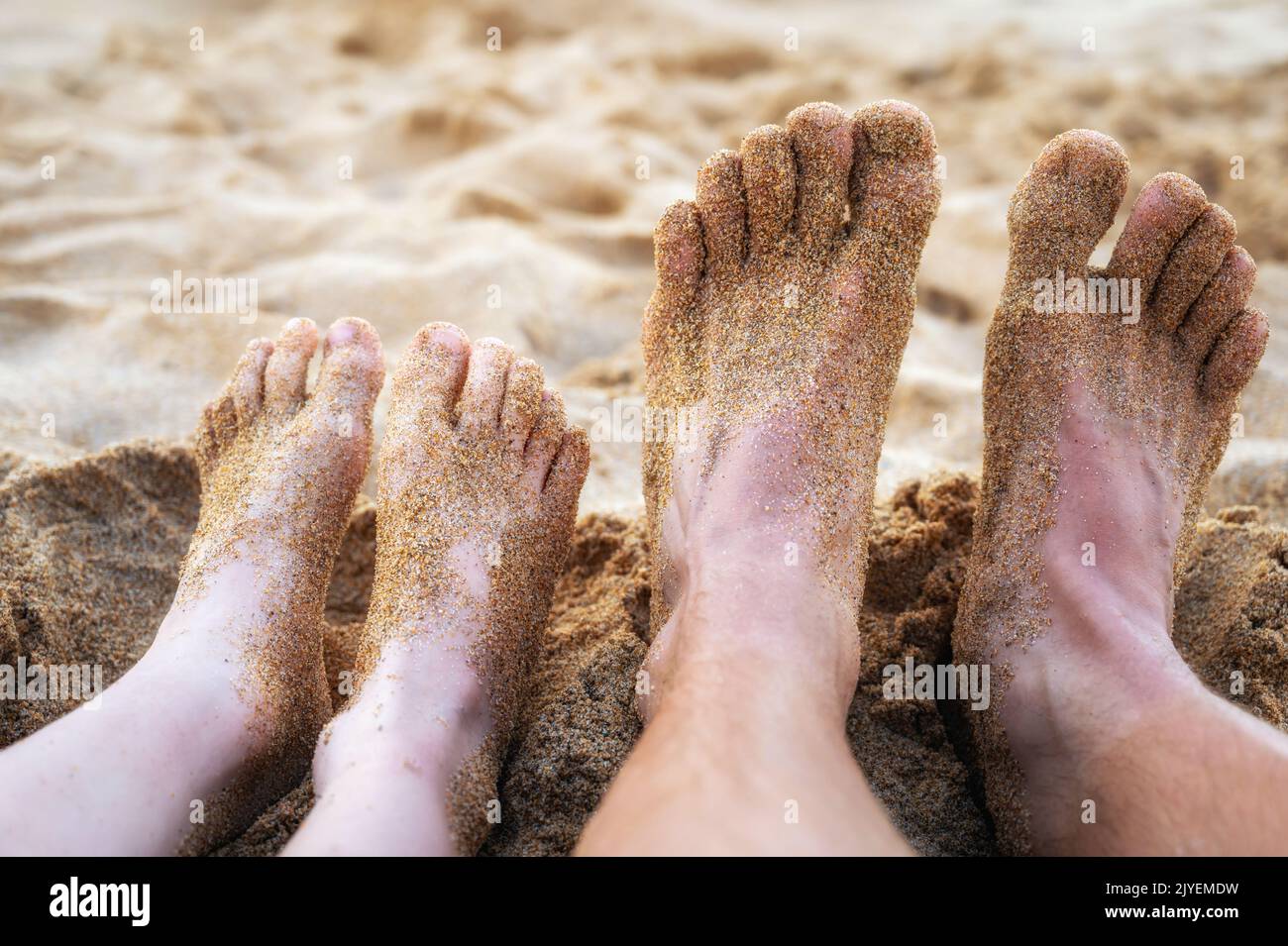 Feet of father and son on a beach on summer vacation Stock Photo