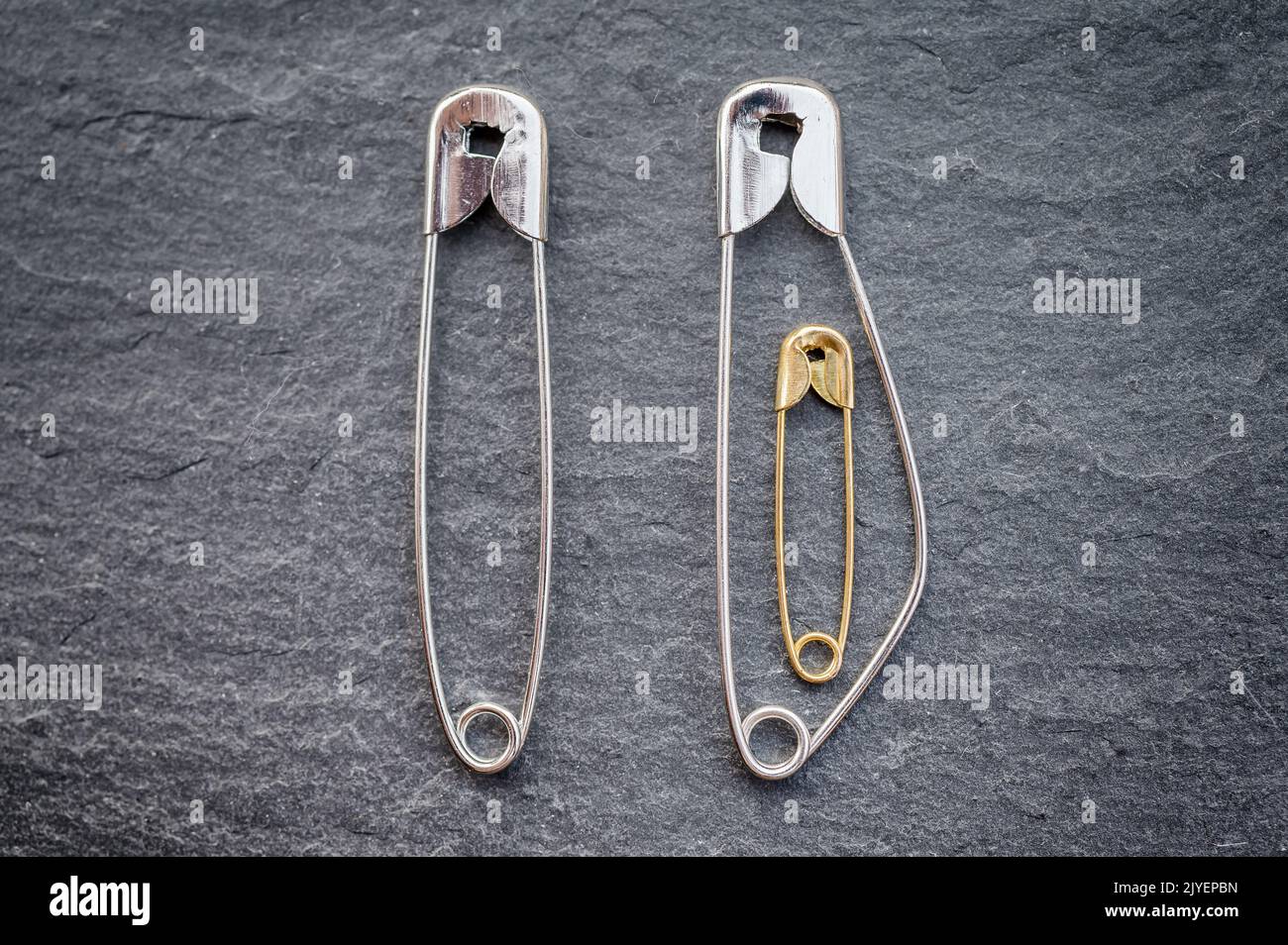 Pregnancy in a relationship depicted with safety pins Stock Photo