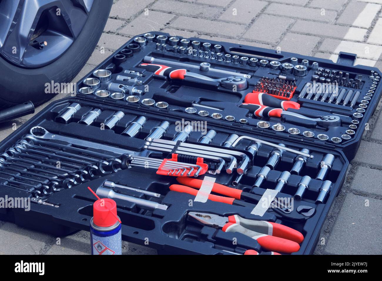 Toolset near the auto. Mechanical workshop tools in box. Using different repair tools for repairing an car. Stock Photo