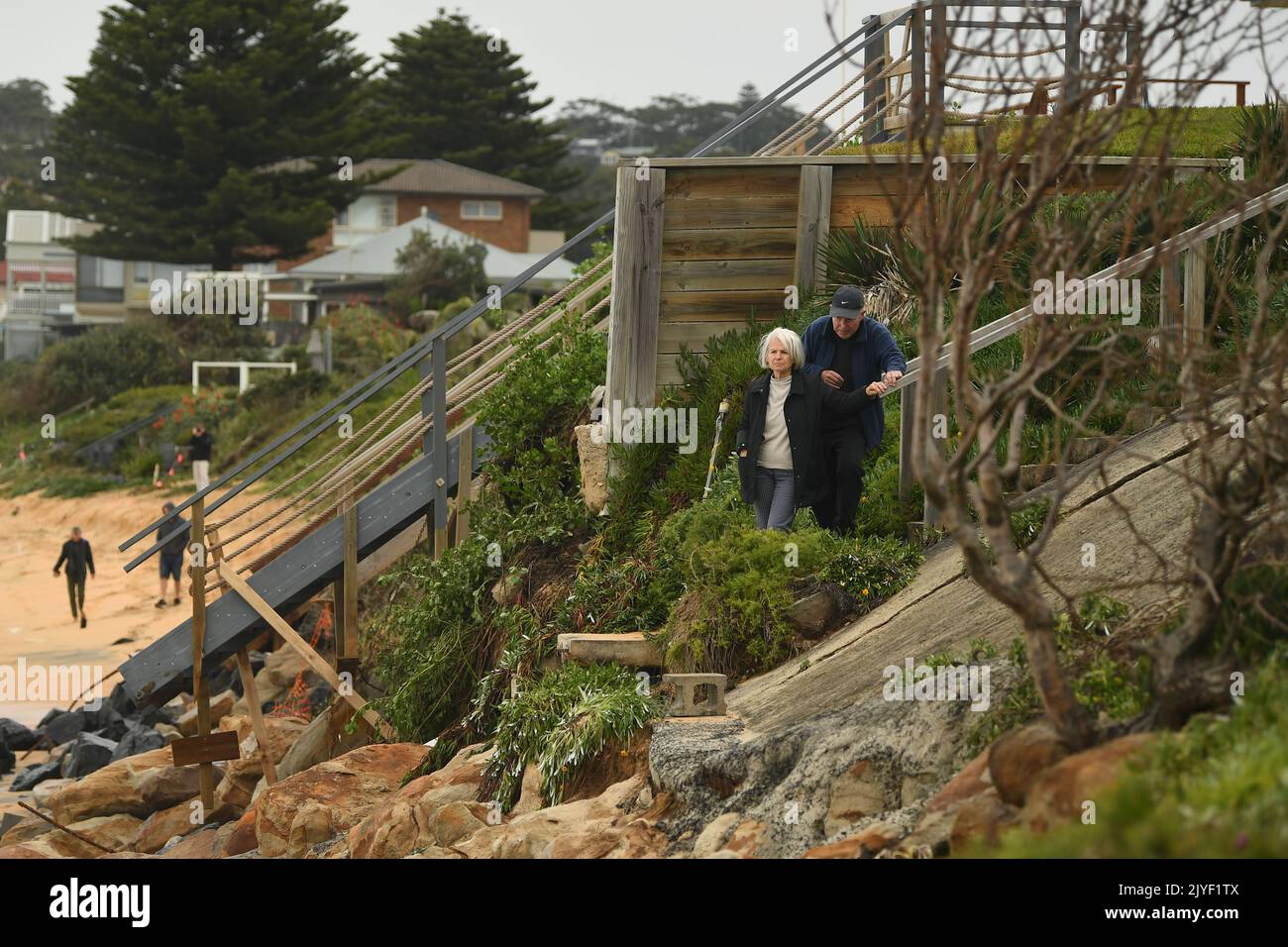 A woman inspects damage at a property on Ocean View Drive at Terrigal