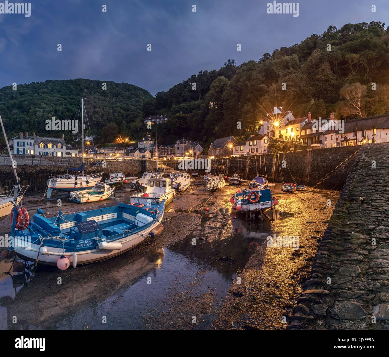 As daylight fades, the lights come on around the small picturesque harbour at Lynmouth on the north coast of Devon. Lynmouth sits at the confluence of Stock Photo