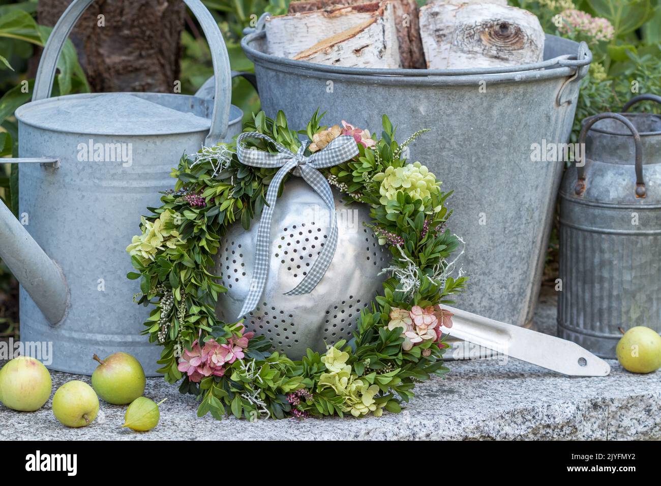 arrangement with wreath of hydrangea flowers and box tree branches and vintage zinc objekts Stock Photo
