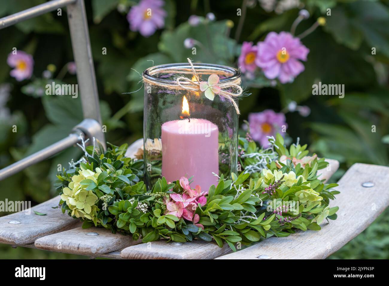 arrangement with wreath of hydrangea flowers and box tree branches and candle Stock Photo
