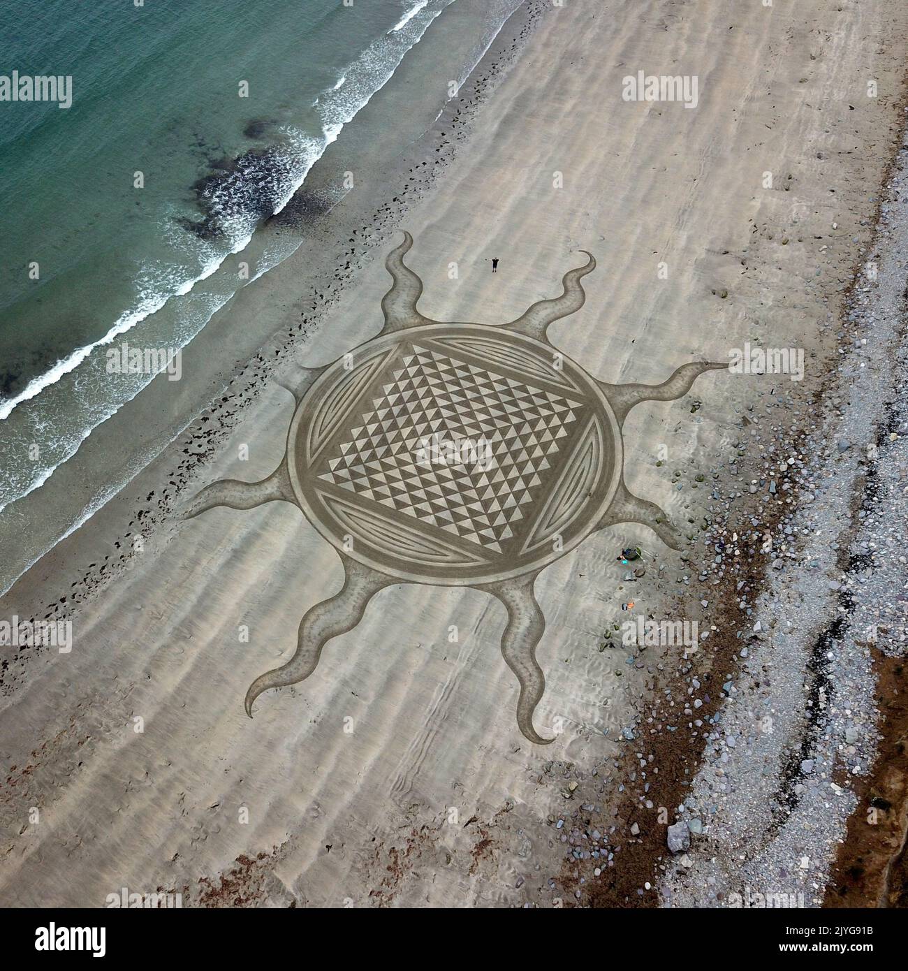 The tide starts to claim this design. Ireland, UK: FROM PSYCHEDELIC patterns to a giant-sized pooch-portraits these are the best of sand art masterpie Stock Photo
