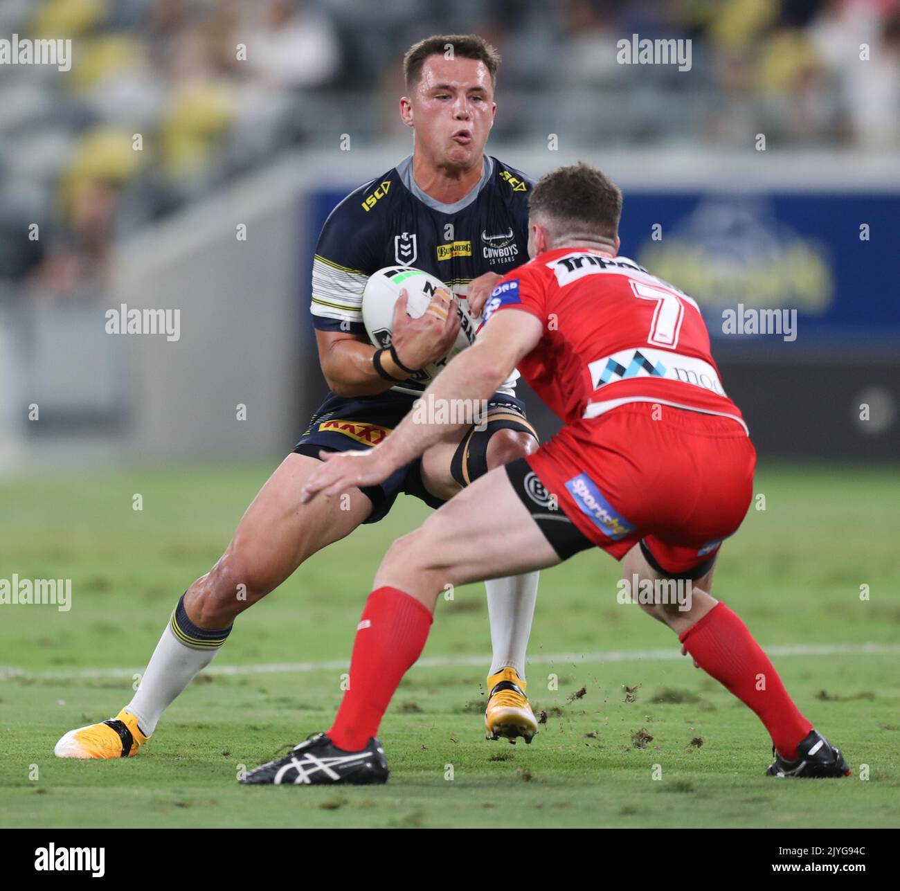 Scott Drinkwater of the Cowboys runs at Adam Clune of the Dragons ...