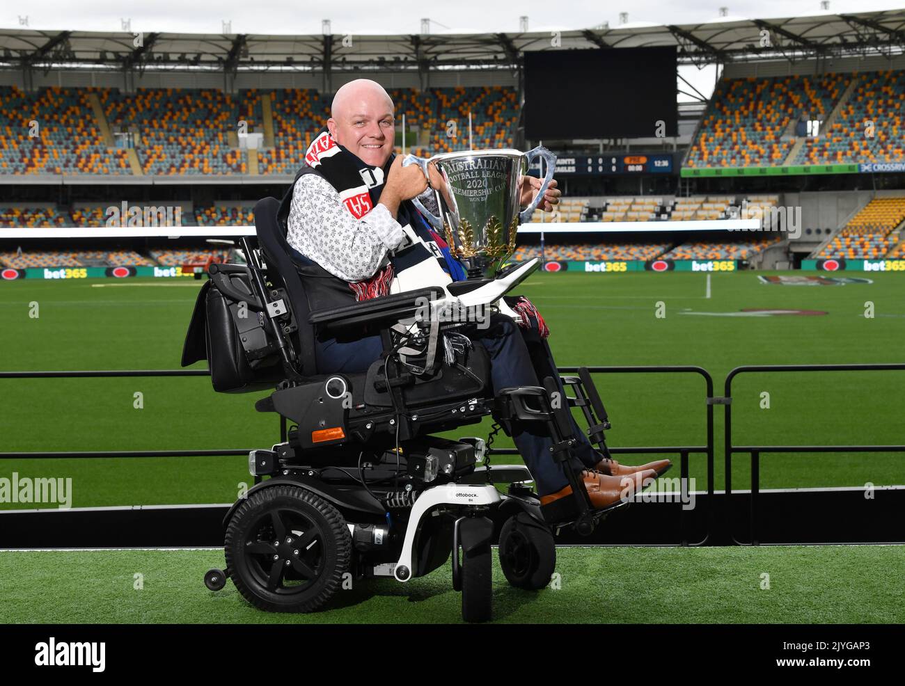 Tim McCallum is seen posing for a photograph with the AFL Premiership