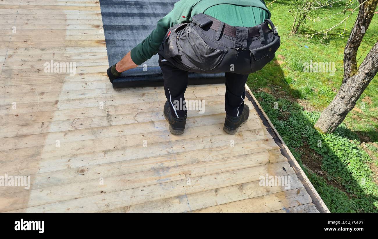Roofing felt welding on bitumen roof roof repair with roofing felt and open flame propane tool on flat roof, leak with free space for text Stock Photo