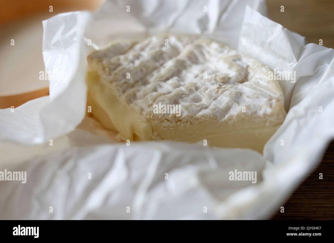 camembert cheese in unwrapped paper Stock Photo