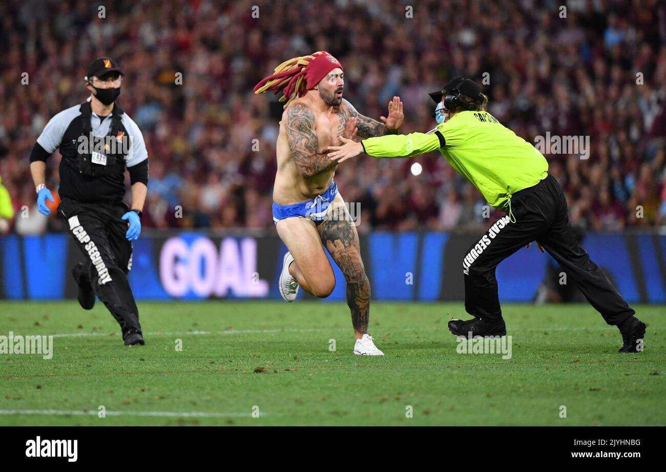 A pitch invader (centre) is seen being being chased by security during Game 3 of the 2020 State A pitch invader (centre) is seen being being chased by security during Game 3 of the 2020 State