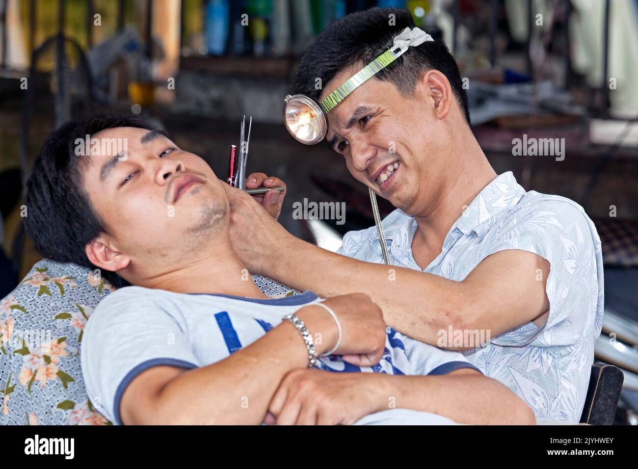 Ear cleaning in barber shop, Hai Phong, Vietnam Stock Photo