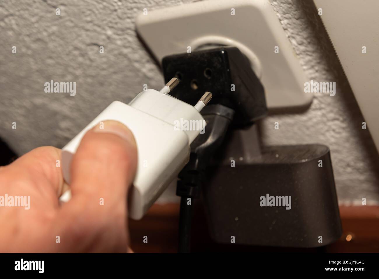 Vaduz, Liechtenstein, September 6, 2022 Electric power plug put in a socket to generate electricity in an apartment Stock Photo