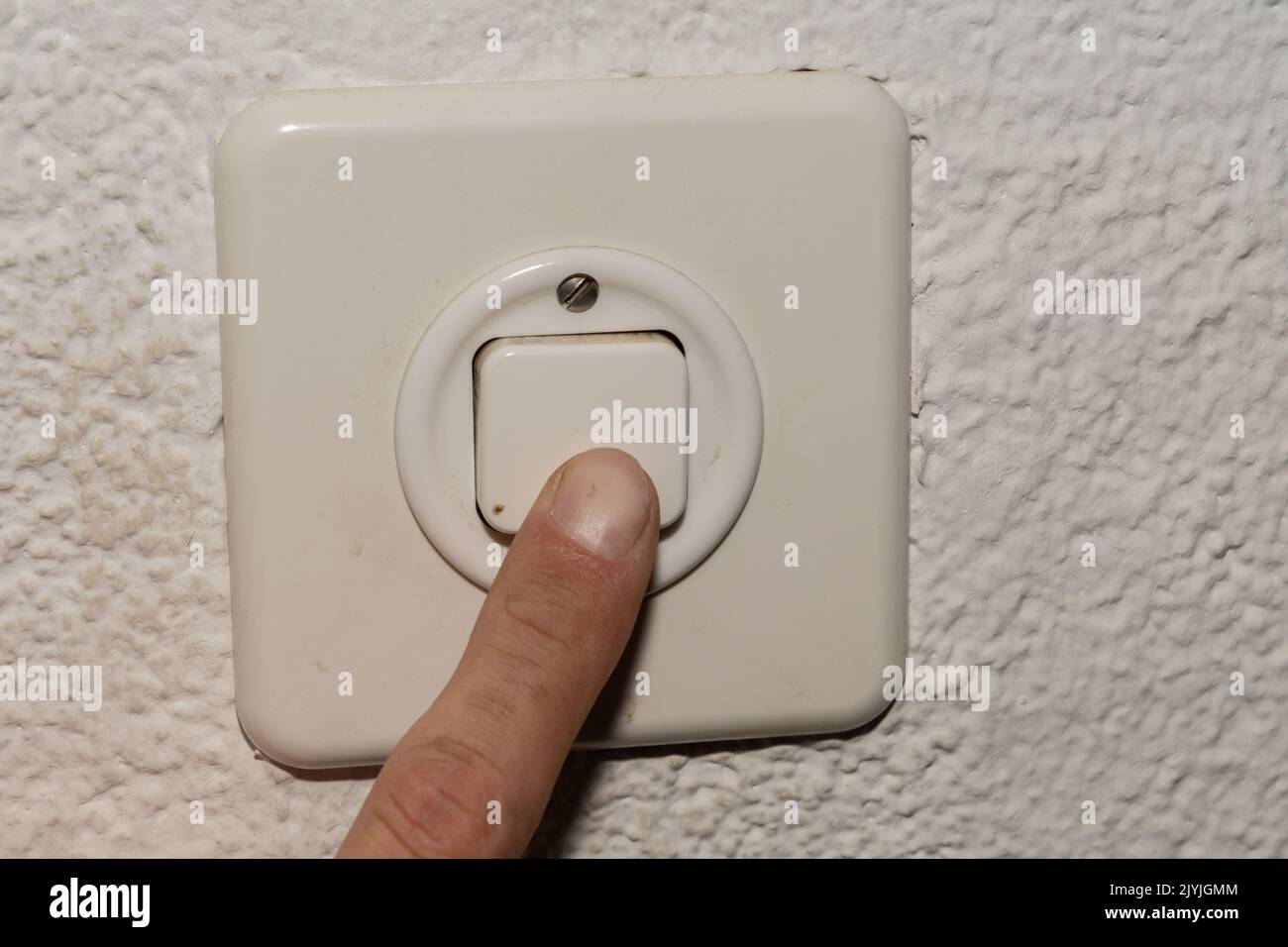 Vaduz, Liechtenstein, September 6, 2022 Index finger is pushing on a light switch in an apartment Stock Photo