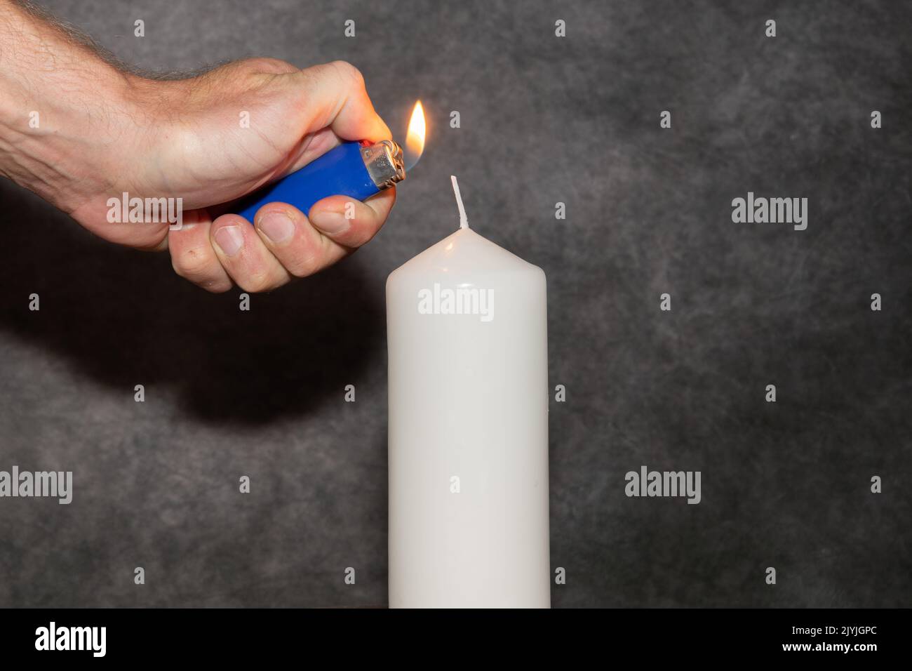 Vaduz, Liechtenstein, September 6, 2022 Lighting on a candle with a small fire Stock Photo
