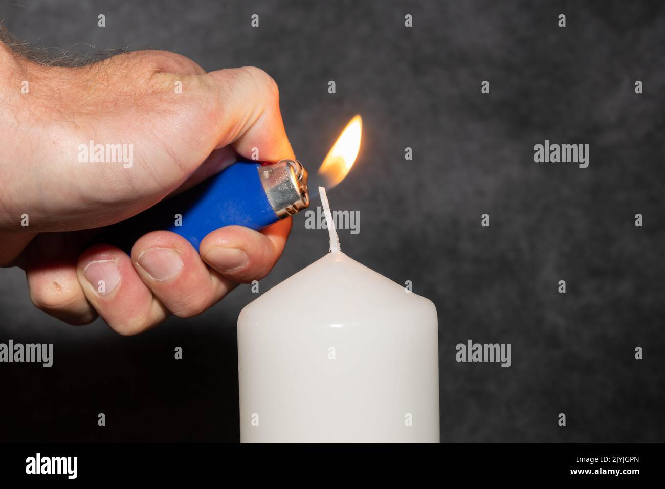 Vaduz, Liechtenstein, September 6, 2022 Lighting on a candle with a small fire Stock Photo