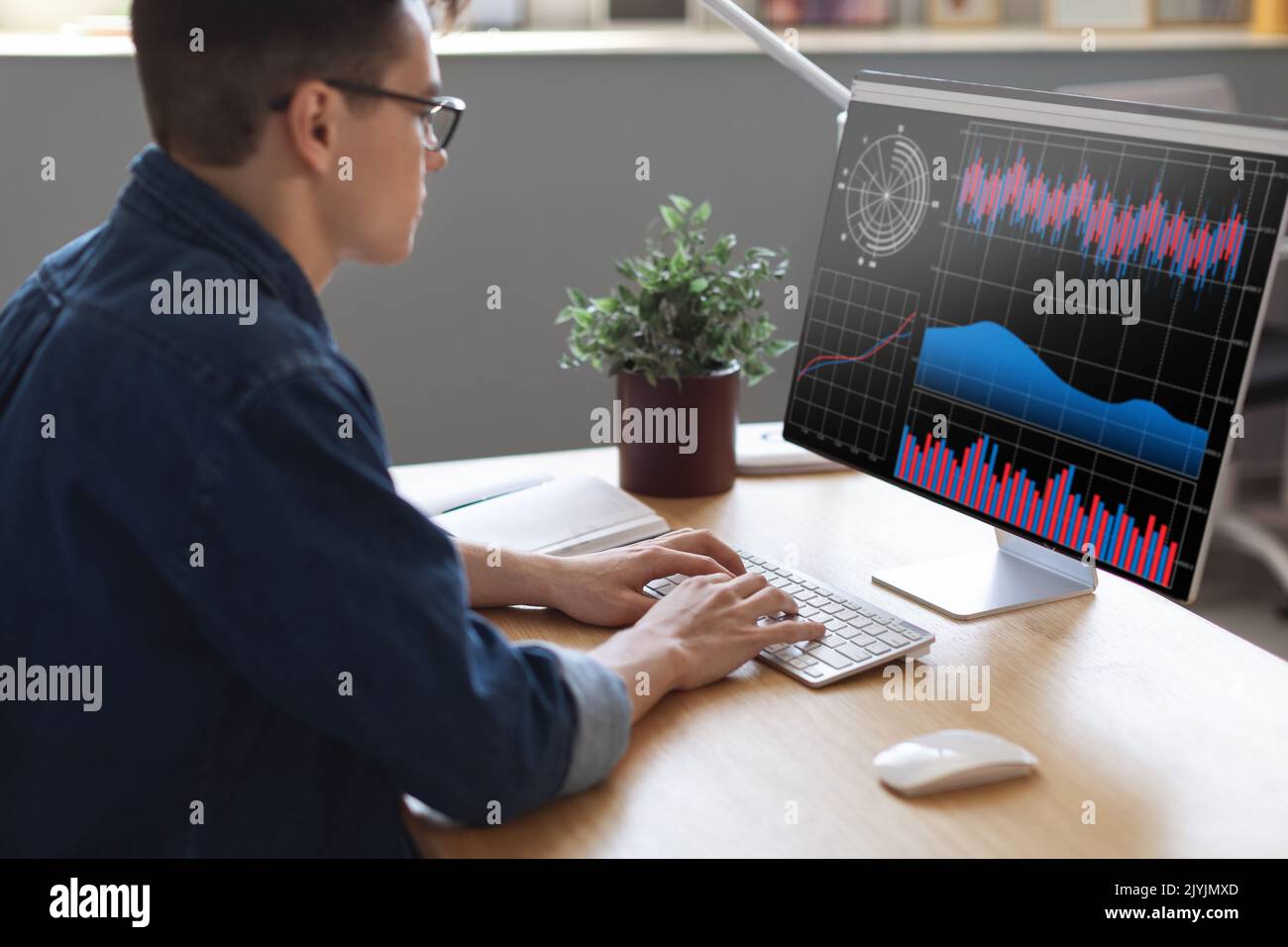 Millennial Businessman Analyzing Financial Statistics On Computer Screen While Working In Office Stock Photo